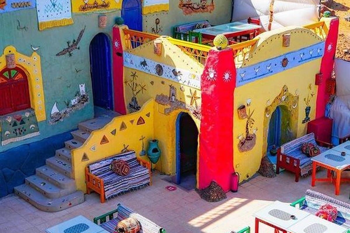 A brightly painted Nubian courtyard in Gharb Soheil near Aswan, set with low tables and woven rugs